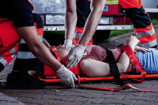 Paramedics treating a woman experiencing cardiac arrest and AED injury.