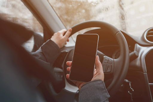 An Uber Eats delivery driver with a phone that is logged on to the app; delivery driver accidents are treated differently when the driver is not actively on-duty.