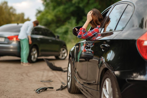 A woman and a man in the aftermath of a sideswipe collision, one of the common accidents caused by blind spots.