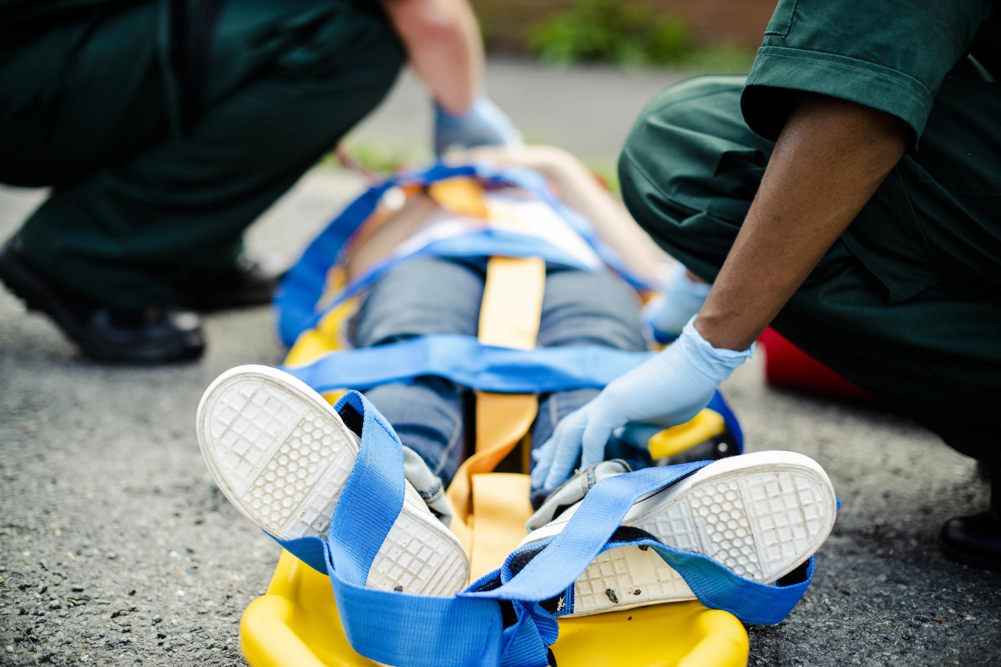 Paramedics work to immobilize a critically injured patient for transport; expert witnesses can often help clarify medical matters in catastrophic injury cases.