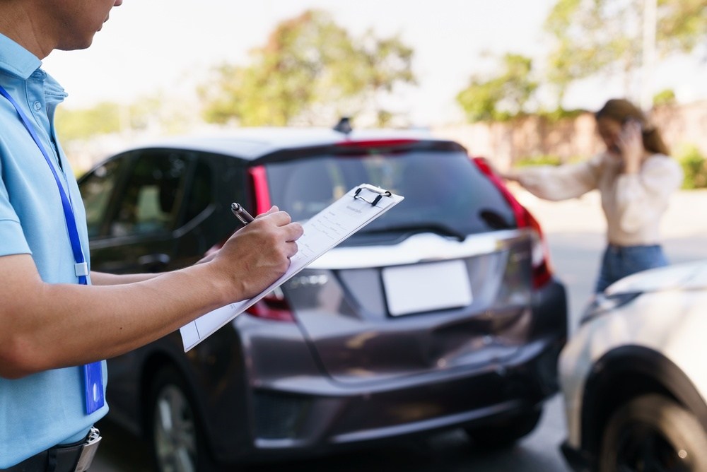 Person filling out an accident report after a car accident near University City, Philadelphia