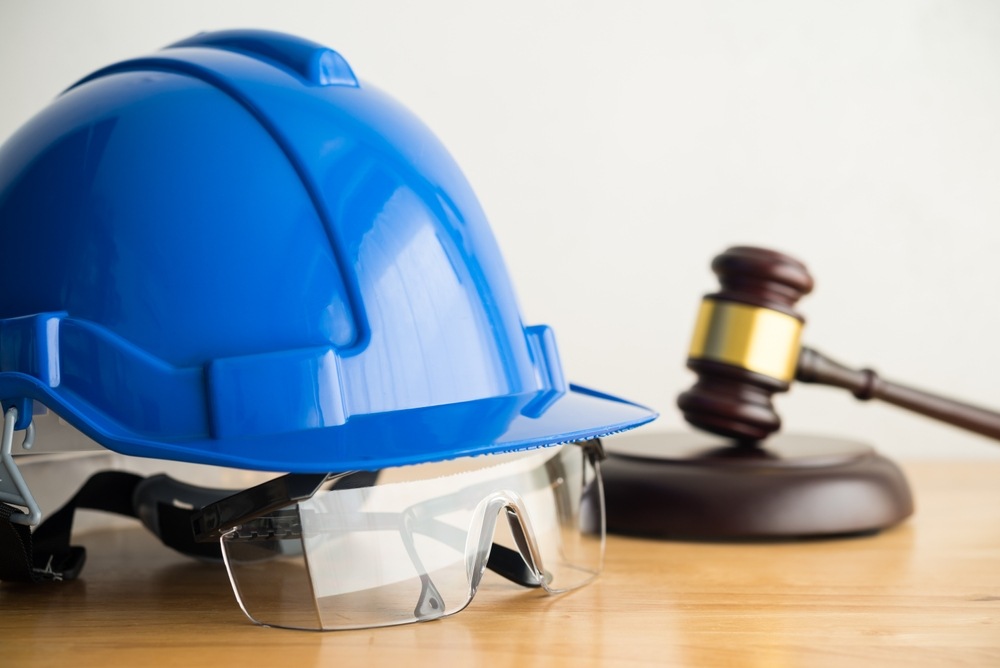 Blue hard hat and safety glasses beside a judge's gavel, representing Philadelphia workers' compensation FAQ answers