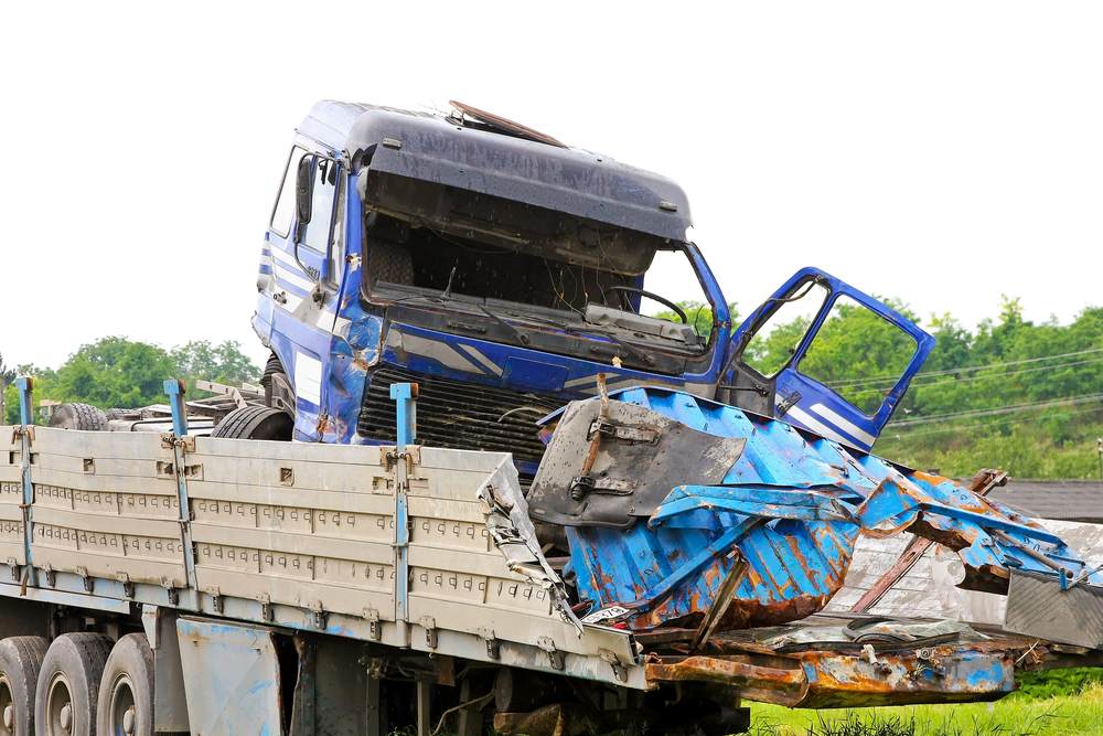 Severely damaged commercial truck with crushed cab after a serious truck accident